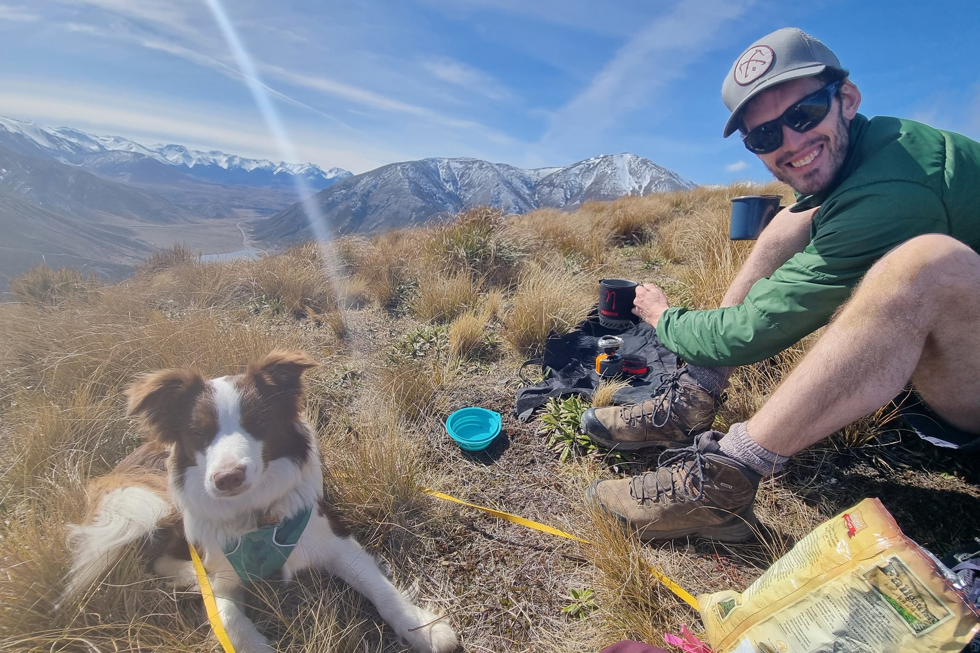 Jason tramping in the NZ mountains with a brown and white border collie Jason tramping in the NZ mountains with a brown and white border collie